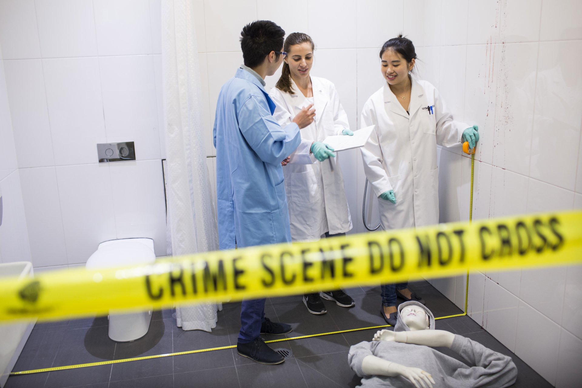 Three students in a simulated crime scene.