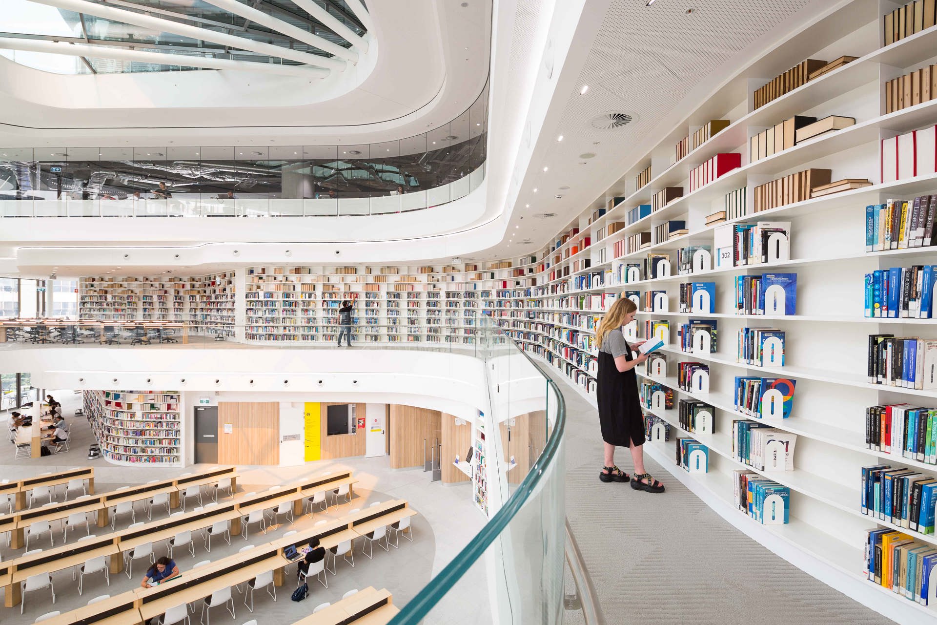 girl standing looking about books in library
