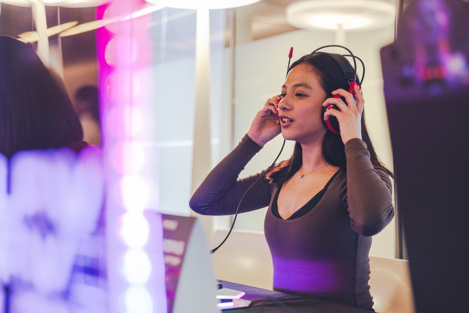 Female student wearing headphones and gaming at UTS Tech Fest.