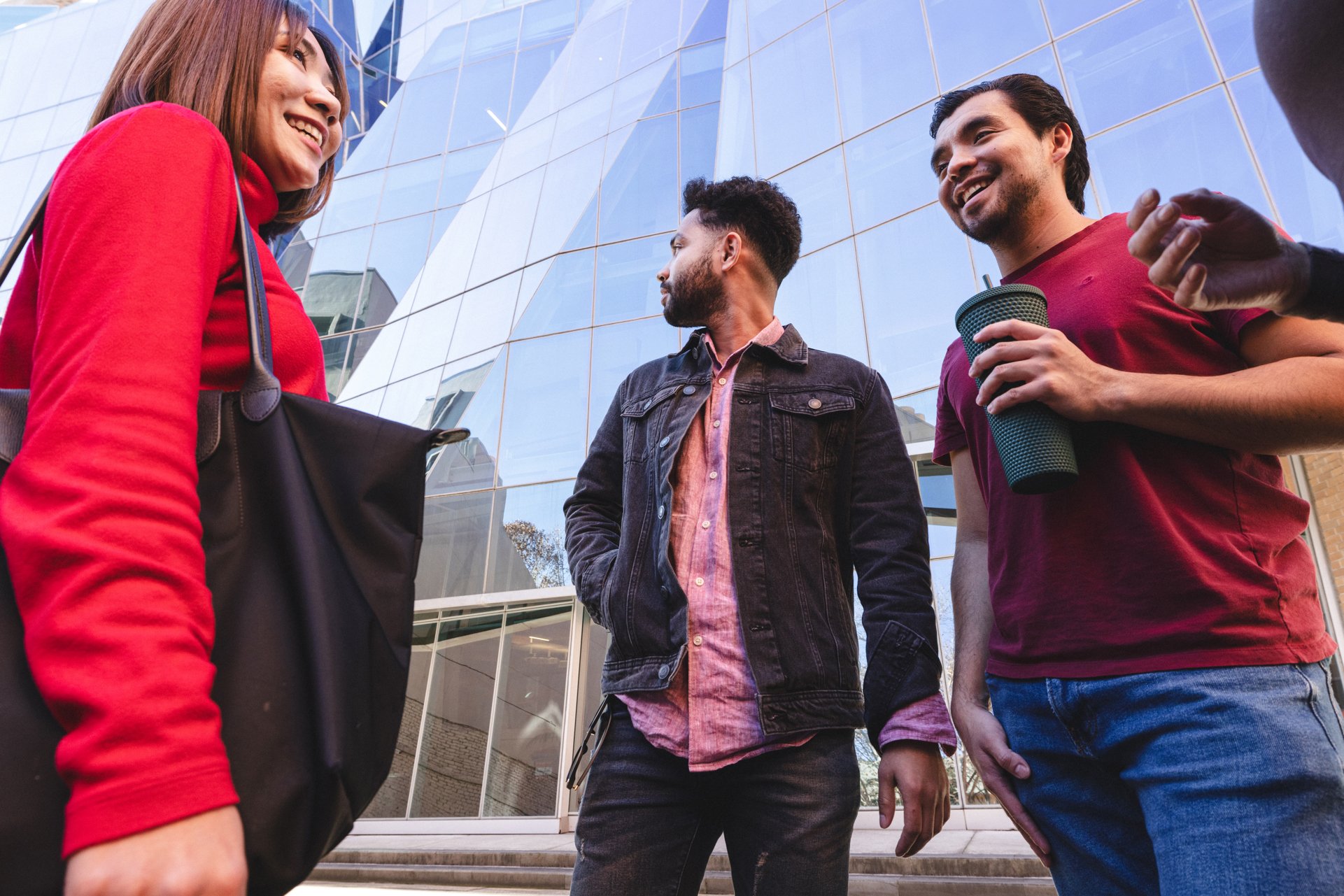 One female and two male students standing outside the UTS Business building.