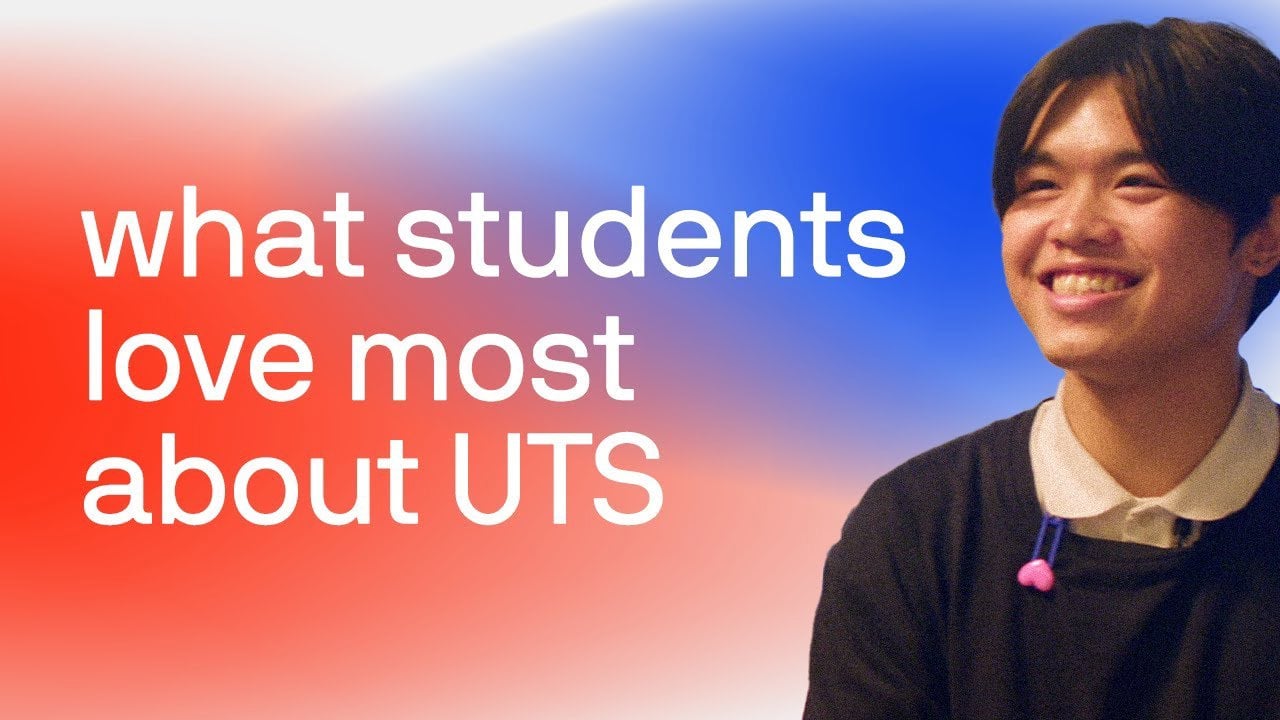 Female student wearing a black UTS t-shirt welcoming people to an information event.